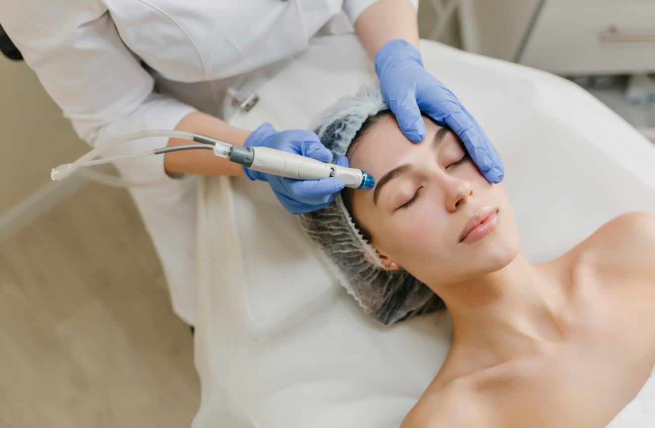 View from above rejuvenation of beautiful woman enjoying cosmetology procedures in beauty salon. Dermatology, hands in blue glows, healthcare, therapy, botox.